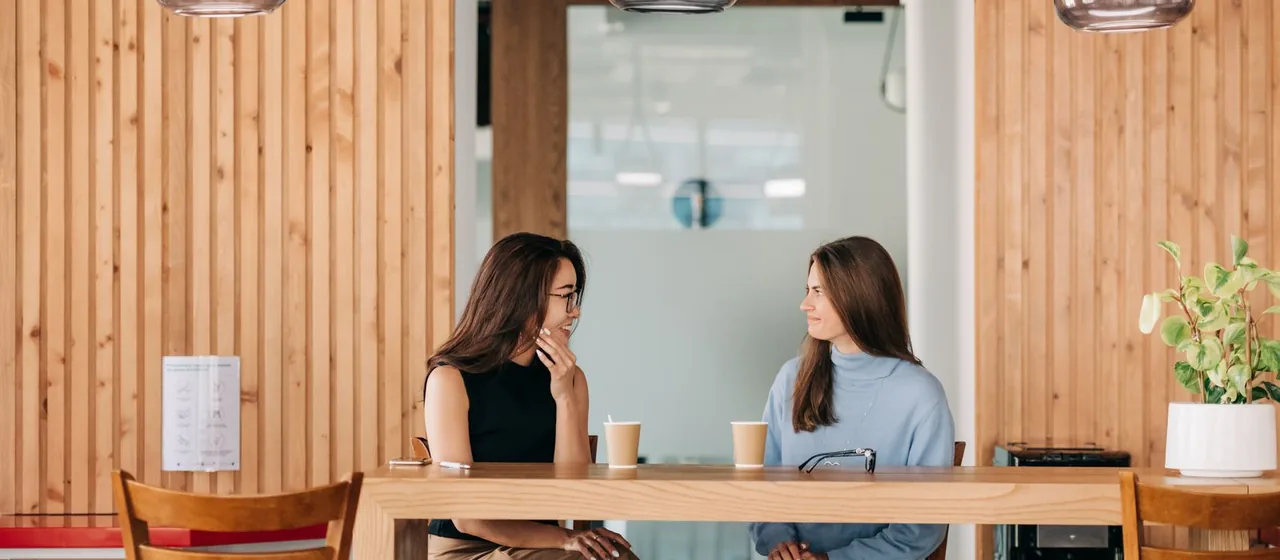 Twee vrouwen voeren een warm gesprek aan een tafel